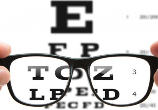 An eye chart seen through a pair of glasses