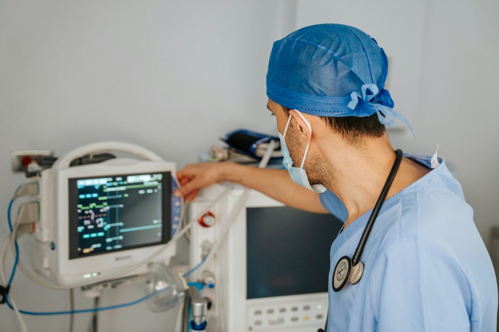 A clinician checking a patient monitor on a hospital ward