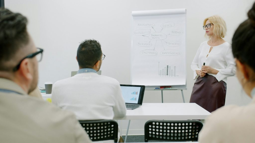 A trainer leading a small group session at a flipchart